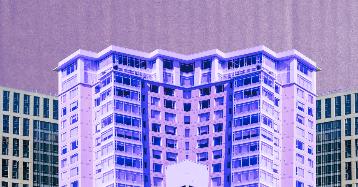 Symmetrical mirrored high-rise with blue-purple hues on a pink background for a real estate article about office vacancies.