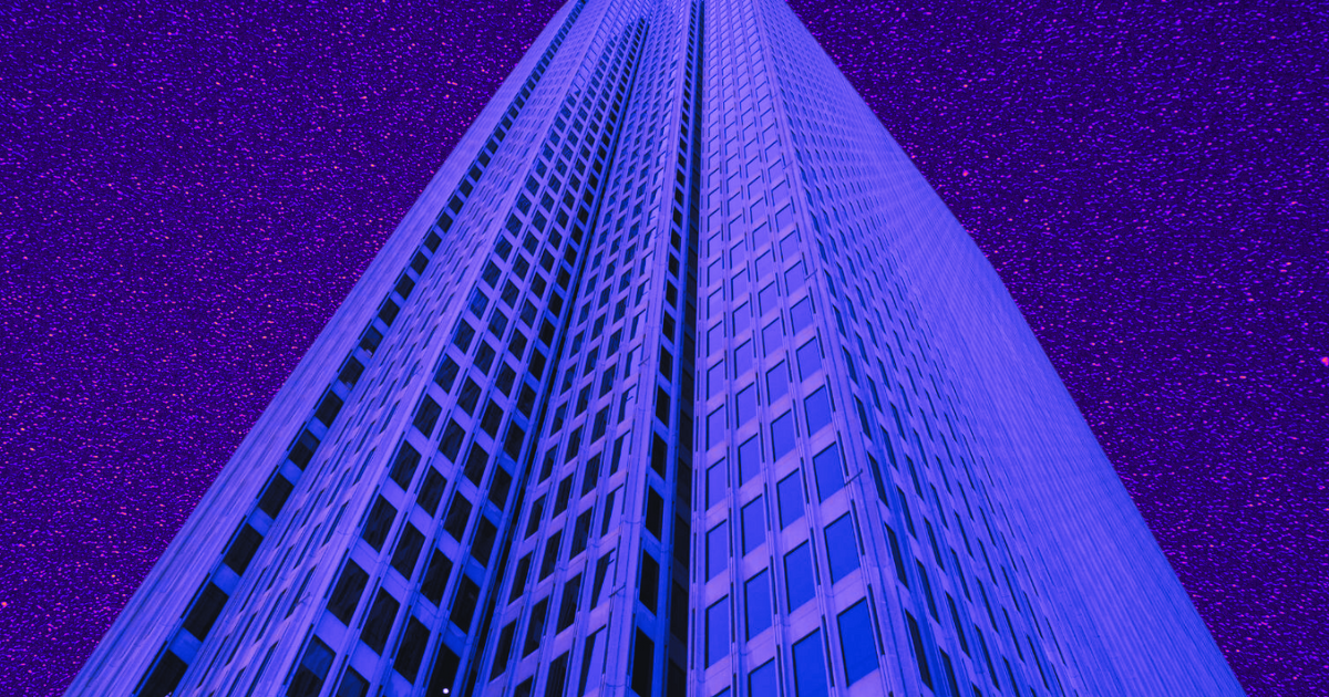 Skyscraper with purple-lit windows against a starry night sky; accompanies article on office vacancies hitting 20% in Q1.