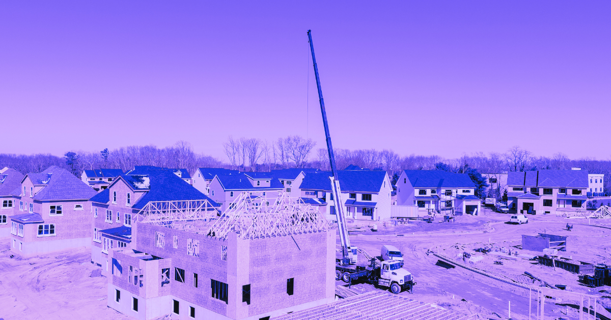 Construction site with houses and crane, set in a residential area with bare trees. Image for real estate article on rental growth.