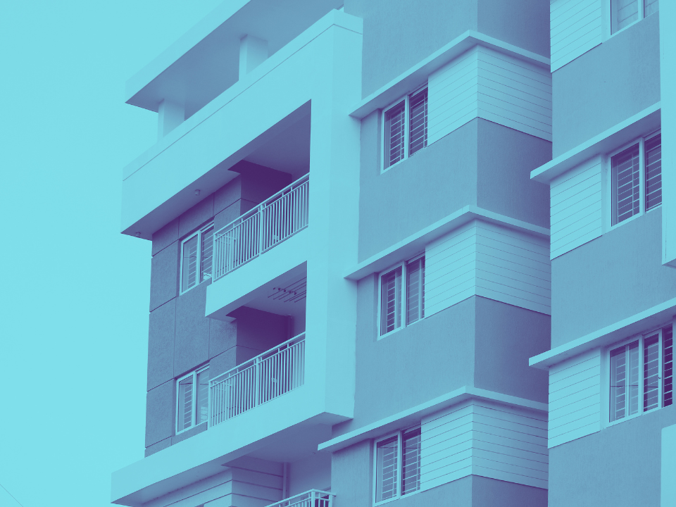 Monochromatic blue modern apartment building with balconies and large windows, featured in real estate article on KKR's $2.1B purchase.