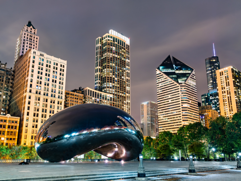 Night view of Chicago's Millennium Park with The Bean and lit skyscrapers, featured in "Chicago Rents Soar Thanks to Summer Demand.