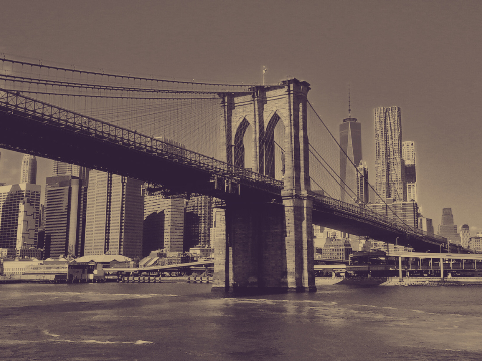 Sepia-toned image of the Brooklyn Bridge and NYC skyline, featuring One World Trade Center. Used for real estate article.