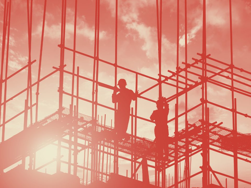 Silhouettes of workers on scaffolding at sunset with orange-red sky. Metal poles form geometric patterns. Article: US Construction Slumps.