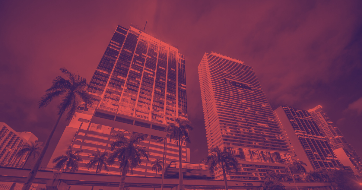 Skyscrapers against dark orange sky, tall palm trees in foreground, for real estate article "MBA: CRE Mortgage Debt Hits $4.7T".